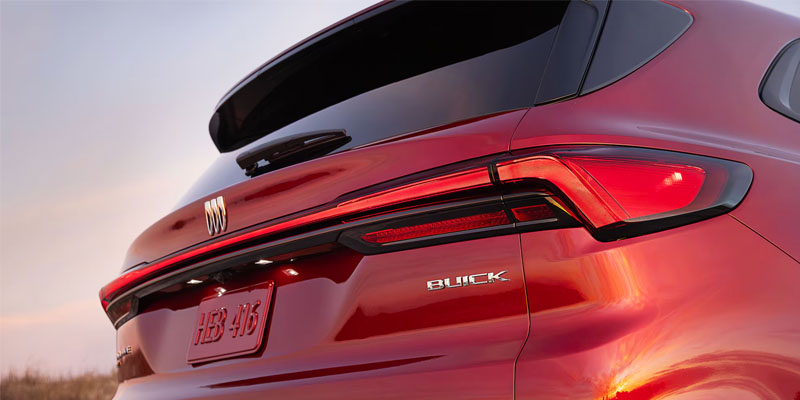 Back of a red 2026 Buick Enclave driving into the sunset in Gilbert, AZ