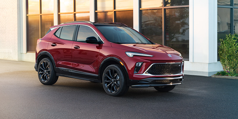 A red Buick Encore GX parked in front of a building.